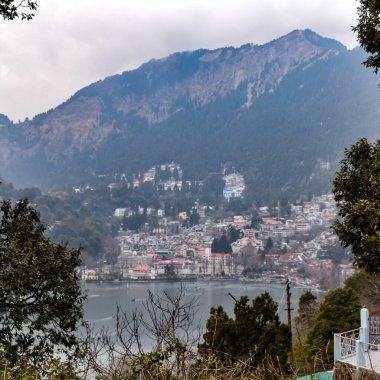 Akşam vakti Nainital, Uttarakhand, Hindistan 'daki Mall Yolu' nun yanındaki Naini Gölü 'nün manzarası dağlarla ve mavi gökyüzüyle güzel Nainital Gölü manzarası.