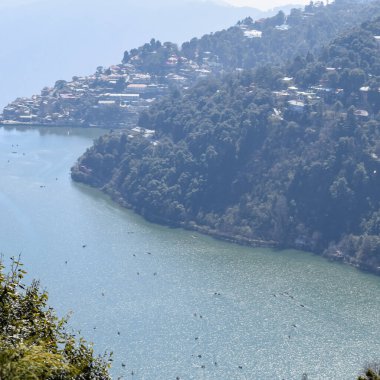 Akşam vakti Nainital, Uttarakhand, Hindistan 'daki Mall Yolu' nun yanındaki Naini Gölü 'nün manzarası dağlarla ve mavi gökyüzüyle güzel Nainital Gölü manzarası.