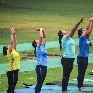 Yeni Delhi, Hindistan, 18 Haziran 2022 Lodhi Garden Parkı 'nda farklı yaşlarda insanlar için grup yoga sınıfı. Uluslararası Yoga Günü, büyük bir grup yetişkin parkta yoga dersine katılıyor.