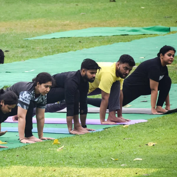 Yeni Delhi, Hindistan, 18 Haziran 2022 Lodhi Garden Parkı 'nda farklı yaşlarda insanlar için grup yoga sınıfı. Uluslararası Yoga Günü, büyük bir grup yetişkin parkta yoga dersine katılıyor.