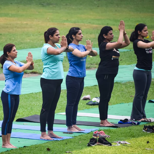 Yeni Delhi, Hindistan, 18 Haziran 2022 Lodhi Garden Parkı 'nda farklı yaşlarda insanlar için grup yoga sınıfı. Uluslararası Yoga Günü, büyük bir grup yetişkin parkta yoga dersine katılıyor.