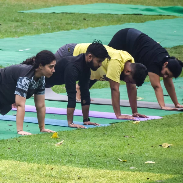 Yeni Delhi, Hindistan, 18 Haziran 2022 Lodhi Garden Parkı 'nda farklı yaşlarda insanlar için grup yoga sınıfı. Uluslararası Yoga Günü, büyük bir grup yetişkin parkta yoga dersine katılıyor.