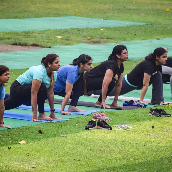 Yeni Delhi, Hindistan, 18 Haziran 2022 Lodhi Garden Parkı 'nda farklı yaşlarda insanlar için grup yoga sınıfı. Uluslararası Yoga Günü, büyük bir grup yetişkin parkta yoga dersine katılıyor.