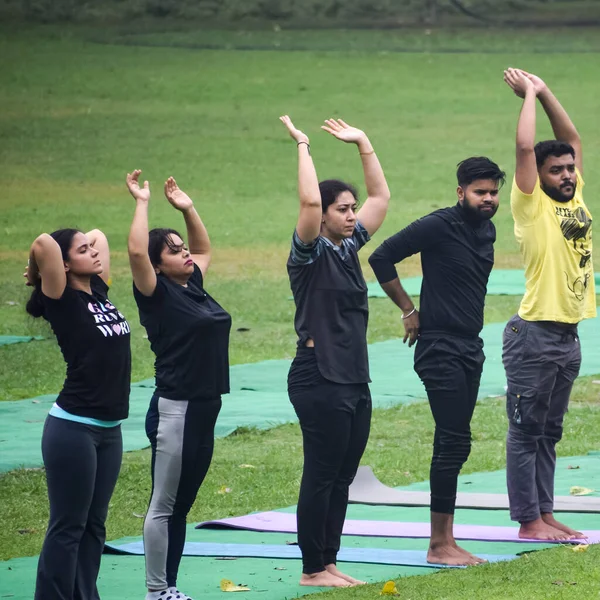 Yeni Delhi, Hindistan, 18 Haziran 2022 Lodhi Garden Parkı 'nda farklı yaşlarda insanlar için grup yoga sınıfı. Uluslararası Yoga Günü, büyük bir grup yetişkin parkta yoga dersine katılıyor.