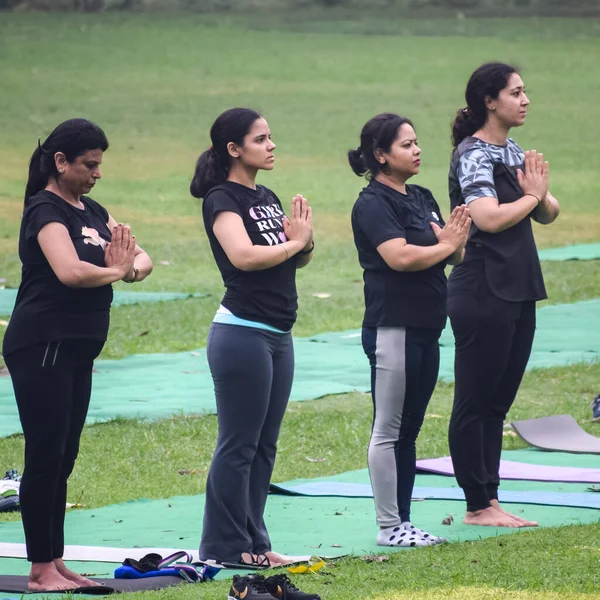 Yeni Delhi, Hindistan, 18 Haziran 2022 Lodhi Garden Parkı 'nda farklı yaşlarda insanlar için grup yoga sınıfı. Uluslararası Yoga Günü, büyük bir grup yetişkin parkta yoga dersine katılıyor.