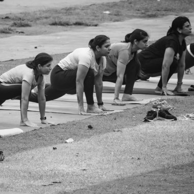 Yeni Delhi, Hindistan, 18 Haziran 2022 - Lodhi Garden Park 'ta farklı yaşlarda insanlar için grup Yoga egzersiz sınıfı. Uluslararası Yoga Günü, parkta yoga derslerine katılan bir grup yetişkin.