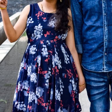 Hintli çift hamilelik çekimleri için poz veriyor. Çift yeşil çimenli bir çimenlikte poz veriyor ve kadın Hindistan, Yeni Delhi 'deki Lodhi Garden' da bebek çarpması yaşıyor.