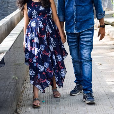 Hintli çift hamilelik çekimleri için poz veriyor. Çift yeşil çimenli bir çimenlikte poz veriyor ve kadın Hindistan, Yeni Delhi 'deki Lodhi Garden' da bebek çarpması yaşıyor.