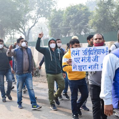 Yeni Delhi, Hindistan 25 Aralık 2021 - Delhi Sözleşmeli Konuk Öğretmenler Delhi AAP Hükümetini protesto eden posterler, bayraklar ve graffitilerle protesto ettiler