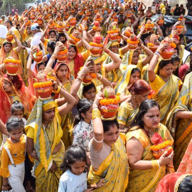 Yeni Delhi, Hindistan 3 Nisan 2022 - Jagannath Tapınağı sırasında Kalaşlı kadınlar Mangal Kalash Yatra, Hintli Hintli dindarlar üzerinde hindistan cevizi olan kutsal su dolu toprak kapları taşıyorlar