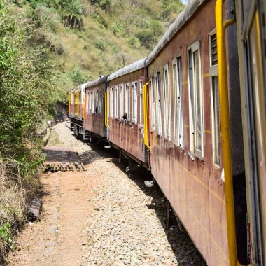 Oyuncak tren dağ yamaçlarında hareket ediyor, güzel bir manzara, bir dağ yamacı, bir vadi yamaçtan tepeye hareket ediyor, yeşil doğal ormanın arasında. Kalka 'dan Shimla' ya giden oyuncak tren Hindistan 'da.