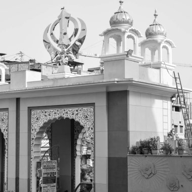 Gurudwara girişinde Khanda Sikh kutsal dini sembolü parlak mavi gökyüzü görüntüsüyle Chandni Chowk 'ta, Eski Delhi' deki Kızıl Kale 'nin karşısındaki Sis Ganj Sahib Gurudwara' da çekildi.