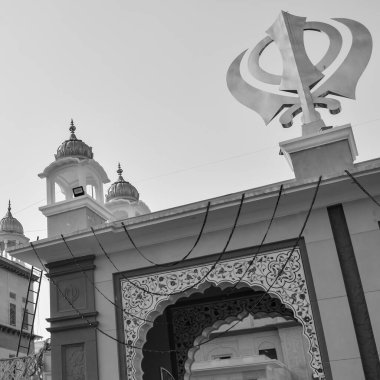Gurudwara girişinde Khanda Sikh kutsal dini sembolü parlak mavi gökyüzü görüntüsüyle Chandni Chowk 'ta, Eski Delhi' deki Kızıl Kale 'nin karşısındaki Sis Ganj Sahib Gurudwara' da çekildi.