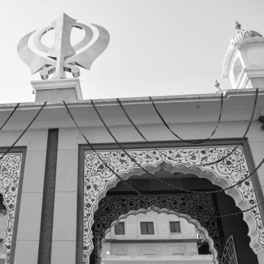 Gurudwara girişinde Khanda Sikh kutsal dini sembolü parlak mavi gökyüzü görüntüsüyle Chandni Chowk 'ta, Eski Delhi' deki Kızıl Kale 'nin karşısındaki Sis Ganj Sahib Gurudwara' da çekildi.