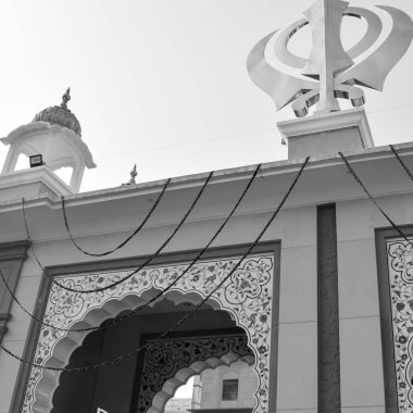 Gurudwara girişinde Khanda Sikh kutsal dini sembolü parlak mavi gökyüzü görüntüsüyle Chandni Chowk 'ta, Eski Delhi' deki Kızıl Kale 'nin karşısındaki Sis Ganj Sahib Gurudwara' da çekildi.