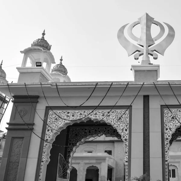 Gurudwara girişinde Khanda Sikh kutsal dini sembolü parlak mavi gökyüzü görüntüsüyle Chandni Chowk 'ta, Eski Delhi' deki Kızıl Kale 'nin karşısındaki Sis Ganj Sahib Gurudwara' da çekildi.