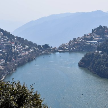 Akşam vakti Nainital, Uttarakhand, Hindistan 'daki Mall Yolu' nun yanındaki Naini Gölü 'nün manzarası dağlarla ve mavi gökyüzüyle güzel Nainital Gölü manzarası.