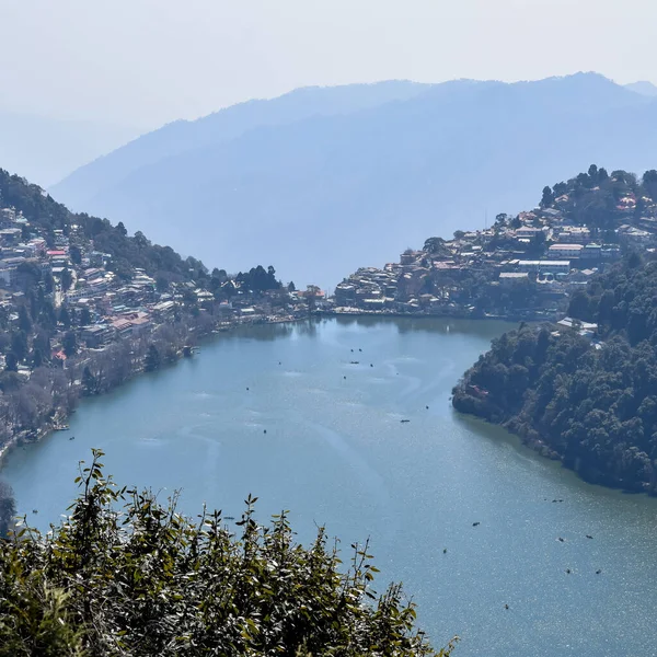 Akşam vakti Nainital, Uttarakhand, Hindistan 'daki Mall Yolu' nun yanındaki Naini Gölü 'nün manzarası dağlarla ve mavi gökyüzüyle güzel Nainital Gölü manzarası.