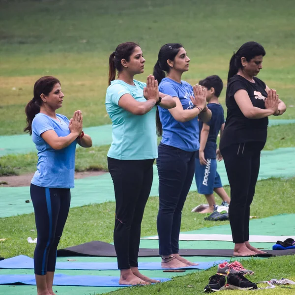 Yeni Delhi, Hindistan, 18 Haziran 2022 - Lodhi Garden 'da farklı yaşlarda insanlar için grup yoga sınıfı Surya Namaskar, Uluslararası Yoga Günü, parkta yoga dersine katılan büyük bir grup yetişkin