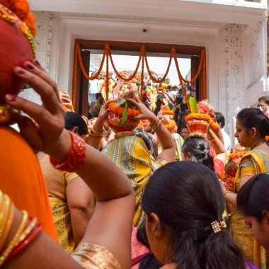 Yeni Delhi, Hindistan 3 Nisan 2022 - Jagannath Tapınağı sırasında Kalaşlı kadınlar Mangal Kalash Yatra, Hintli Hintli dindarlar üzerinde hindistan cevizi olan kutsal su dolu toprak kapları taşıyorlar