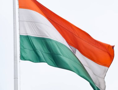 India flag flying high at Connaught Place with pride in blue sky, India flag fluttering, Indian Flag on Independence Day and Republic Day of India, tilt up shot, Waving Indian flag, Har Ghar Tiranga