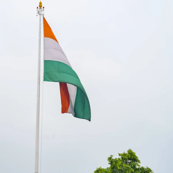 India flag flying high at Connaught Place with pride in blue sky, India flag fluttering, Indian Flag on Independence Day and Republic Day of India, tilt up shot, Waving Indian flag, Har Ghar Tiranga