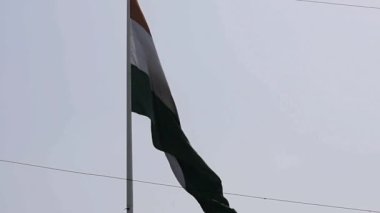 India flag flying high at Connaught Place with pride in blue sky, India flag fluttering, Indian Flag on Independence Day and Republic Day of India, tilt up shot, Waving Indian flag, Har Ghar Tiranga
