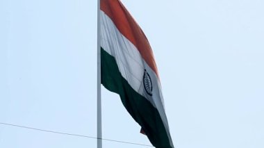 India flag flying high at Connaught Place with pride in blue sky, India flag fluttering, Indian Flag on Independence Day and Republic Day of India, tilt up shot, Waving Indian flag, Har Ghar Tiranga