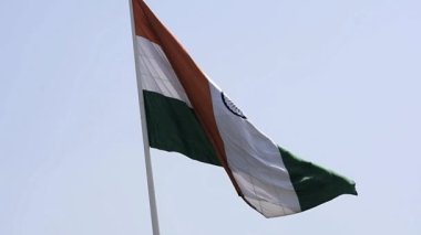 India flag flying high at Connaught Place with pride in blue sky, India flag fluttering, Indian Flag on Independence Day and Republic Day of India, tilt up shot, Waving Indian flag, Har Ghar Tiranga