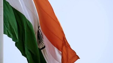 India flag flying high at Connaught Place with pride in blue sky, India flag fluttering, Indian Flag on Independence Day and Republic Day of India, tilt up shot, Waving Indian flag, Har Ghar Tiranga