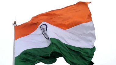 India flag flying high at Connaught Place with pride in blue sky, India flag fluttering, Indian Flag on Independence Day and Republic Day of India, tilt up shot, Waving Indian flag, Har Ghar Tiranga