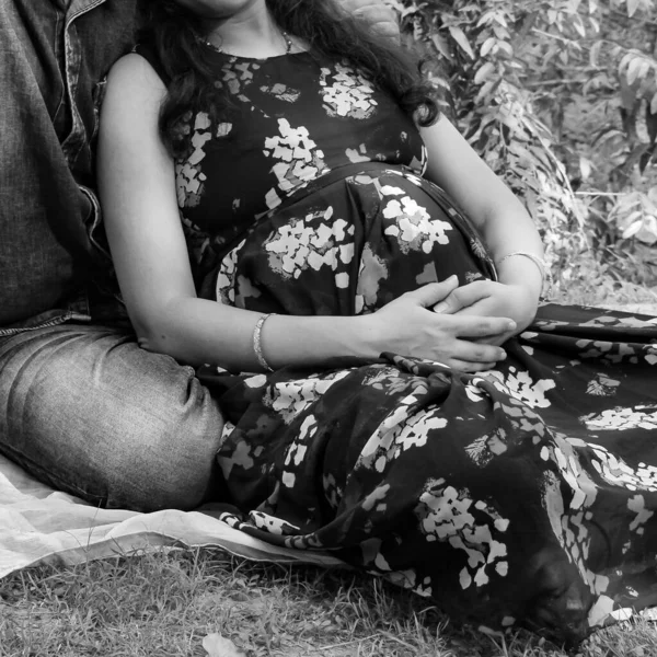 一对印度夫妇摆出生育婴儿的姿势 这对夫妇躺在草坪上 草坪上长满了青草 而这位女士则在印度新德里的Lodhi花园 黑白相间的草地上摇晃着她的小宝宝 — 图库照片