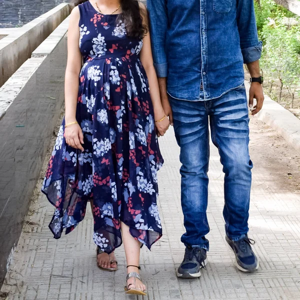 Hintli çift hamilelik çekimleri için poz veriyor. Çift yeşil çimenli bir çimenlikte poz veriyor ve kadın Hindistan, Yeni Delhi 'deki Lodhi Garden' da bebek çarpması yaşıyor.