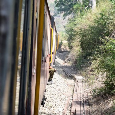 Oyuncak tren dağ yamaçlarında hareket ediyor, güzel bir manzara, bir dağ yamacı, bir vadi yamaçtan tepeye hareket ediyor, yeşil doğal ormanın arasında. Hindistan 'da Kalka' dan Shimla 'ya giden oyuncak tren, Hint treni.