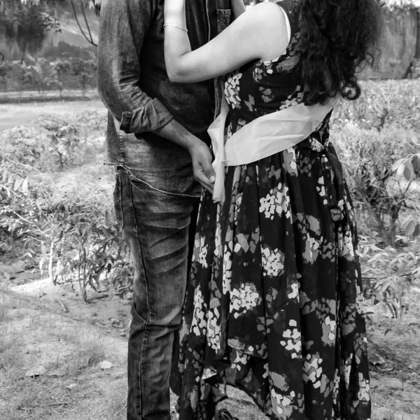乳児撮影のためにポーズをとるインドのカップル 二人は緑の芝生の芝生の中でポーズをとっており 女性はインドのニューデリーにあるロディ ガーデンで赤ん坊のバンプを落下しています 黒と白 — ストック写真