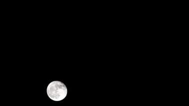 Moon Timelapse, Stock zamanaşımı: Dolunay karanlık gökyüzünde yükseliyor, gece vakti. Dolunay zamanı, gece karanlığında karanlık gökyüzünde ay ışığıyla birlikte kaybolur. Yüksek kaliteli beleş video kaydı veya zaman ayarlı
