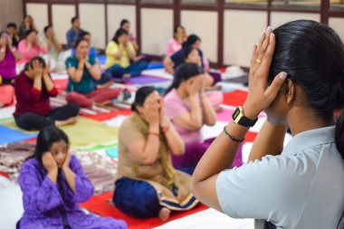 New Delhi, India, June 19 2022 -Group Yoga exercise session for people of different age groups in Balaji Temple, Vivek Vihar, International Yoga Day, Big group of adults attending yoga class in temple