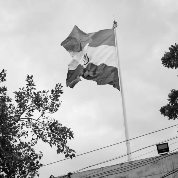 India flag flying at Connaught Place with pride in blue sky, India flag fluttering, Indian Flag on Independence Day and Republic Day of India, waving Indian flag, Flying India flags - Black and White