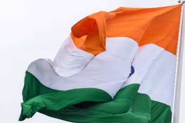 India flag flying high at Connaught Place with pride in blue sky, India flag fluttering, Indian Flag on Independence Day and Republic Day of India, tilt up shot, Waving Indian flag, Har Ghar Tiranga
