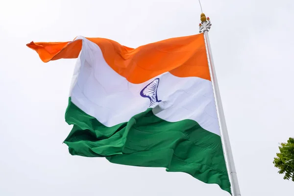 India flag flying high at Connaught Place with pride in blue sky, India flag fluttering, Indian Flag on Independence Day and Republic Day of India, tilt up shot, Waving Indian flag, Har Ghar Tiranga