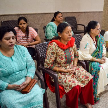 New Delhi, India, June 19 2022 -Group Yoga exercise session for people of different age groups in Balaji Temple, Vivek Vihar, International Yoga Day, Big group of adults attending yoga class in temple