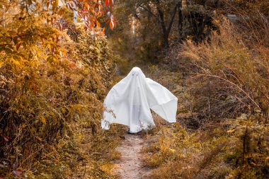Cadılar Bayramı hayaleti gibi giyinmiş küçük bir kız. Çocuk Cadılar Bayramı 'nda hayalet kostümüyle eğleniyor..