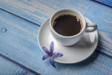 - Kahve. Mavi ahşap bir masada beyaz bir fincan kahve..