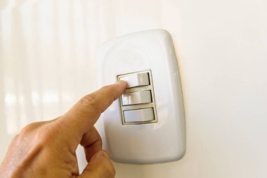 Duvarda beyaz elektrik düğmesi var. El açmak ya da kapatmak. Brezilya enerji krizi.