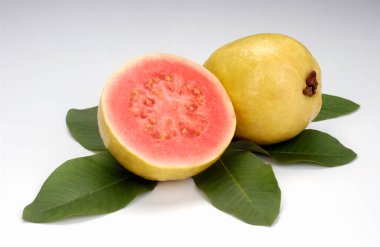 Guavas, ikiye bölünmüş ve beyaz arka planda kalmış. Tropik meyve.