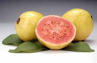 Guavas, ikiye bölünmüş ve beyaz arka planda kalmış. Tropik meyve.