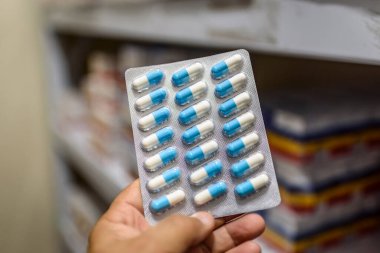 Haplar paketin içinde. Bulanık bir geçmişi olan eczanede el ele tutuşma hapları..