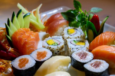 Japon yemeği karışımı, suşi ve beyaz tabakta sashimi..