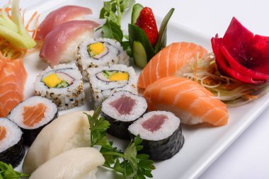 Japon yemeği karışımı, suşi ve beyaz tabakta sashimi..