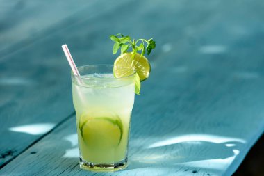 Caipirinha mavi ahşap bir masada limonla içer. Tipik Brezilya içkisi..